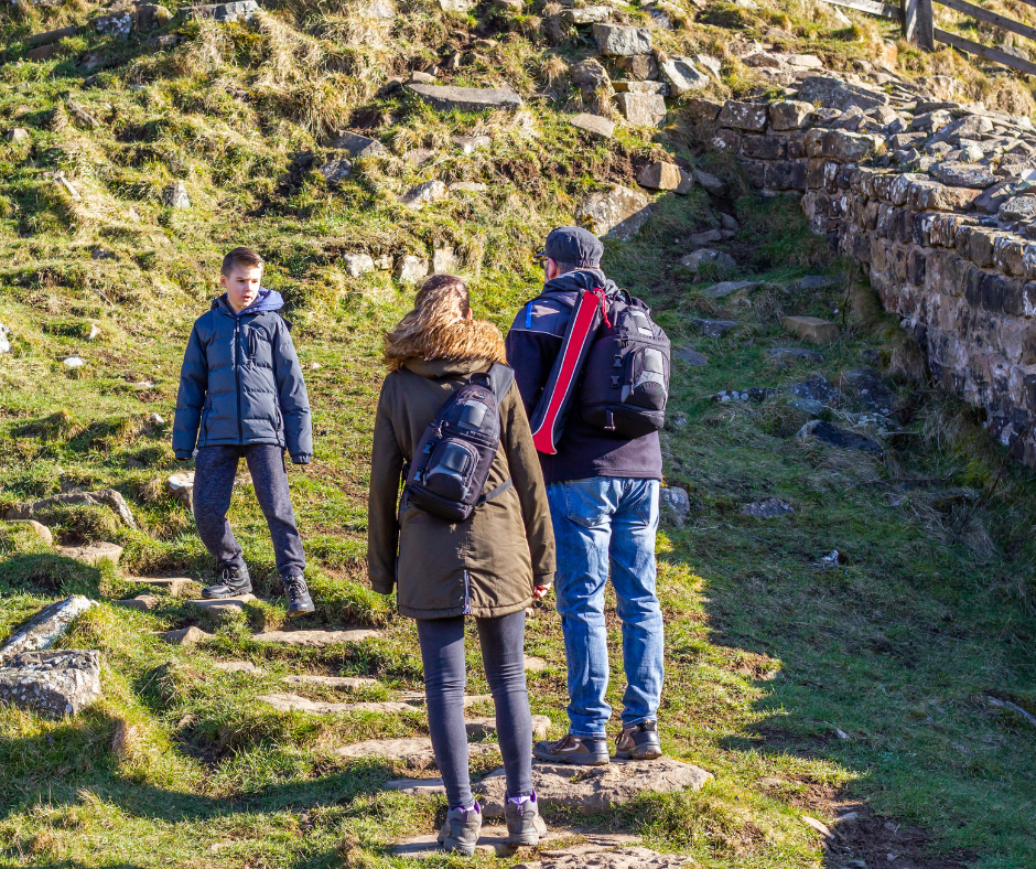 3 people hiking up a hill